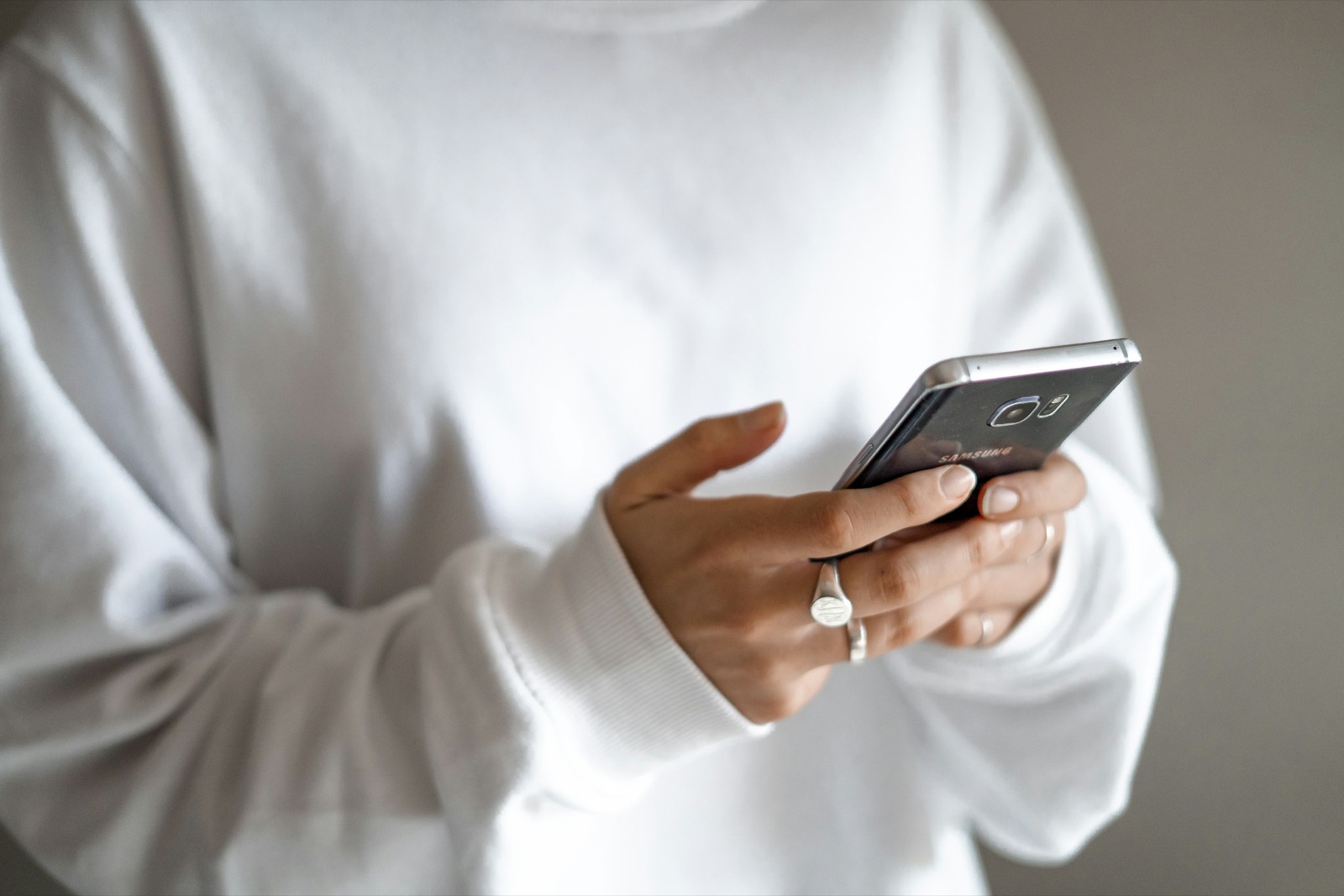 person holding black smartphone with messaging app open on screen