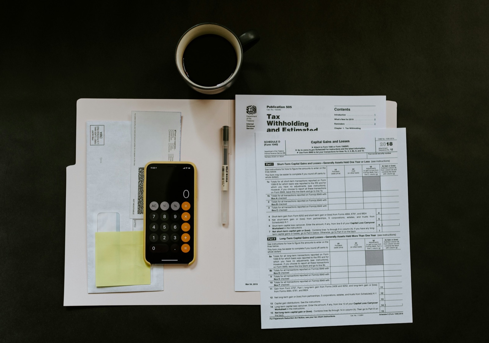 tax paperwork and documents spread on desk with pen and smartphone